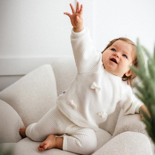 Ecru-Babypullover mit Schleifen