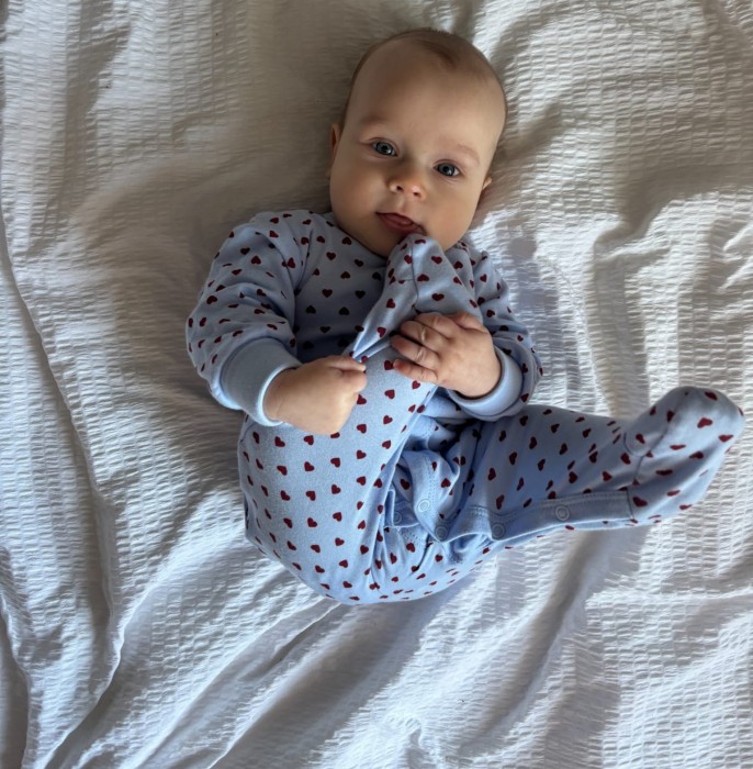 Blauer Baby-Strampler mit Herzchen und umklappbaren Ärmeln